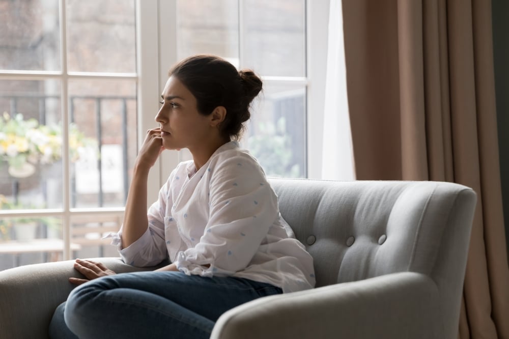 Distressed woman sitting by window