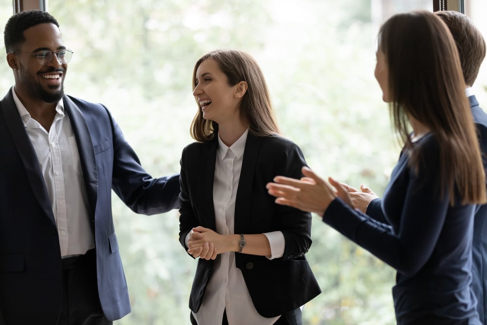 Group of business people applauding woman in center