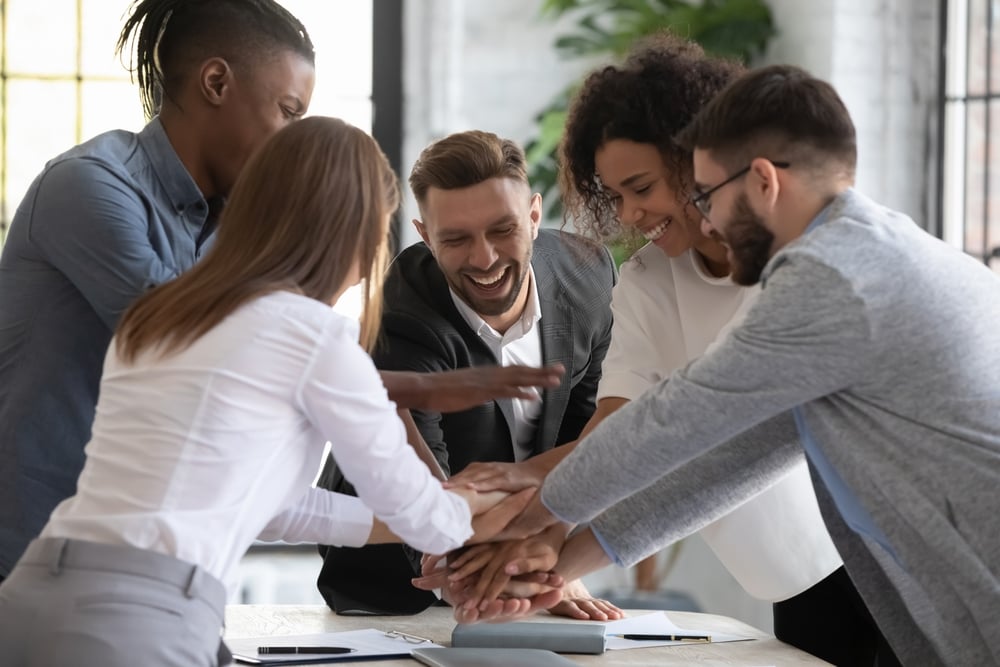 Team of workers with hands placed on top of each other