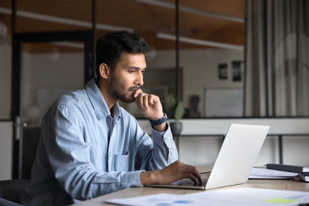 Man in office looking at laptop