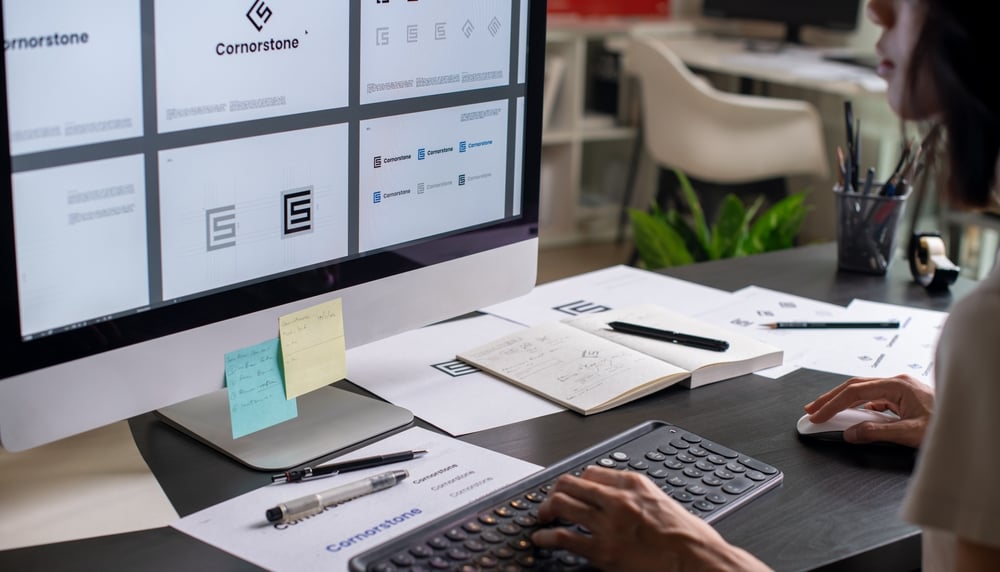 Woman looking at computer monitor of graphic designs