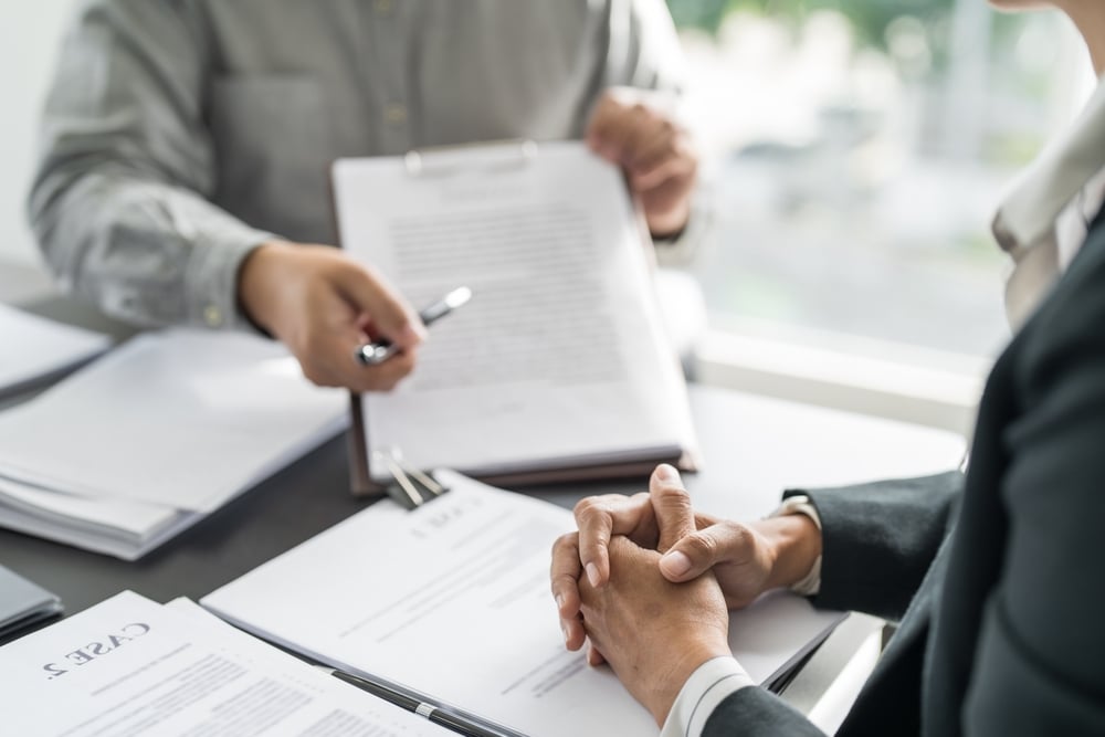 Two people sitting a desk reviewing documents