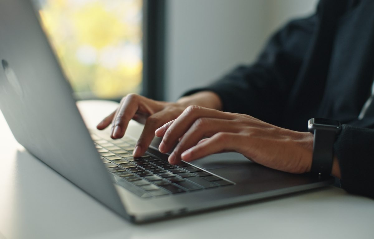 Closeup of hands typing on a laptop.