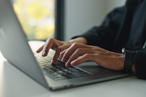 Closeup of hands typing on a laptop.