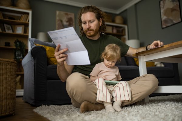 Concerned father looking over expenses with his young daughter.