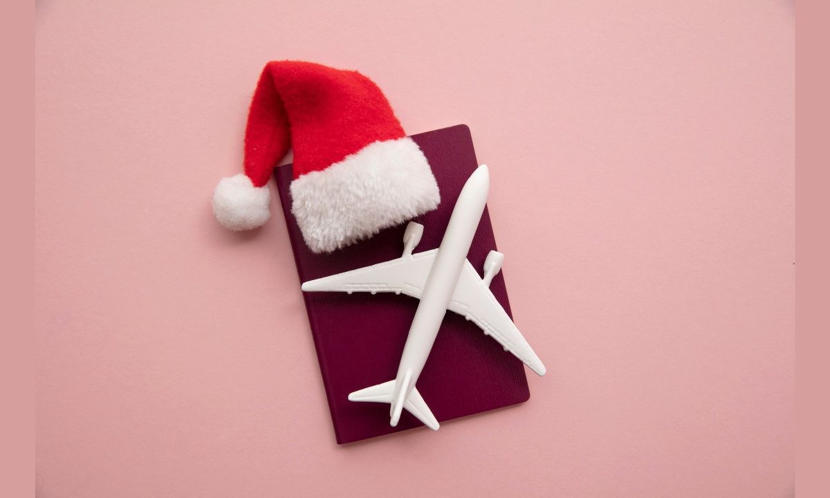 santa hat and airplane on red background holiday travel