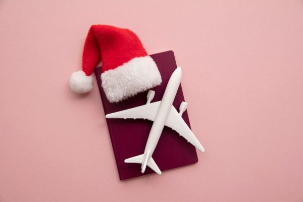 santa hat and airplane on red background holiday travel