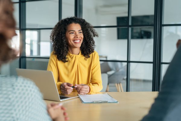 Middle aged businesswoman sits at an interview, considering a career change.
