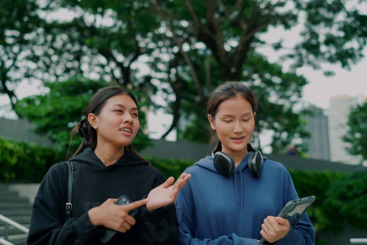 Two young women are walking and having a conversation about their OPT options on an F-1 visa.