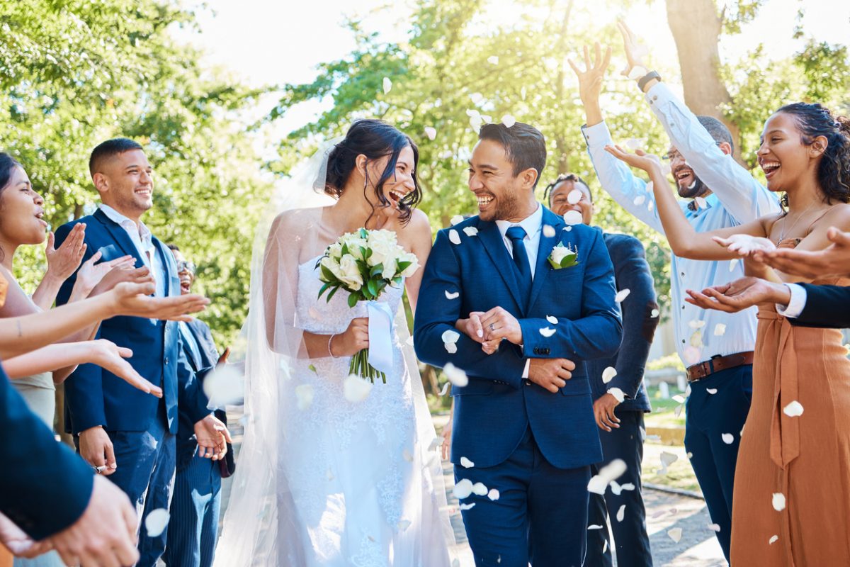 A happy couple on their wedding day surrounded by guests.