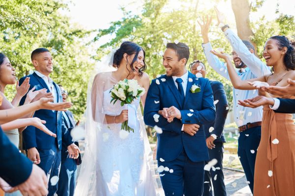 A happy couple on their wedding day surrounded by guests.