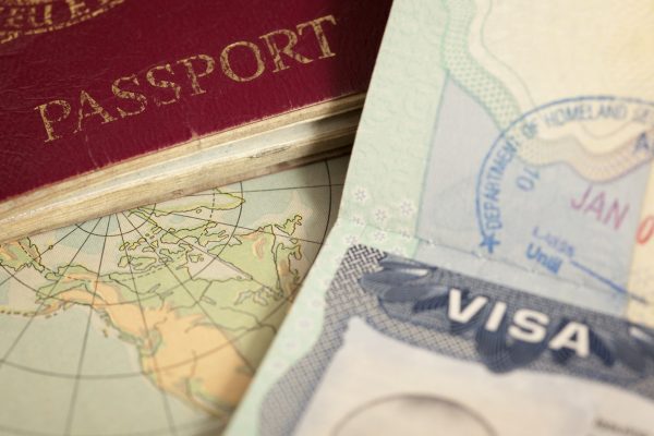 Closeup of a passport cover next to a visa stamped by the Department of Homeland Security