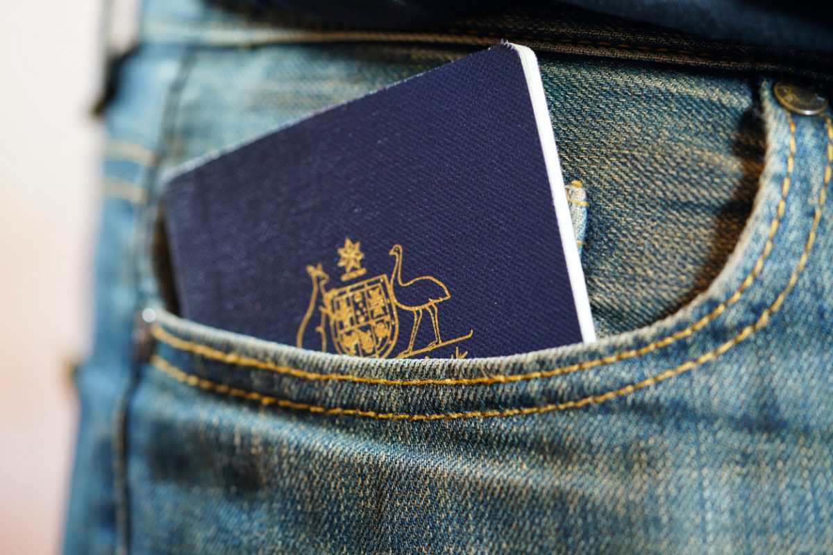 Closeup of an Australian passport hidden in the pocket of a jeans worn by a person.