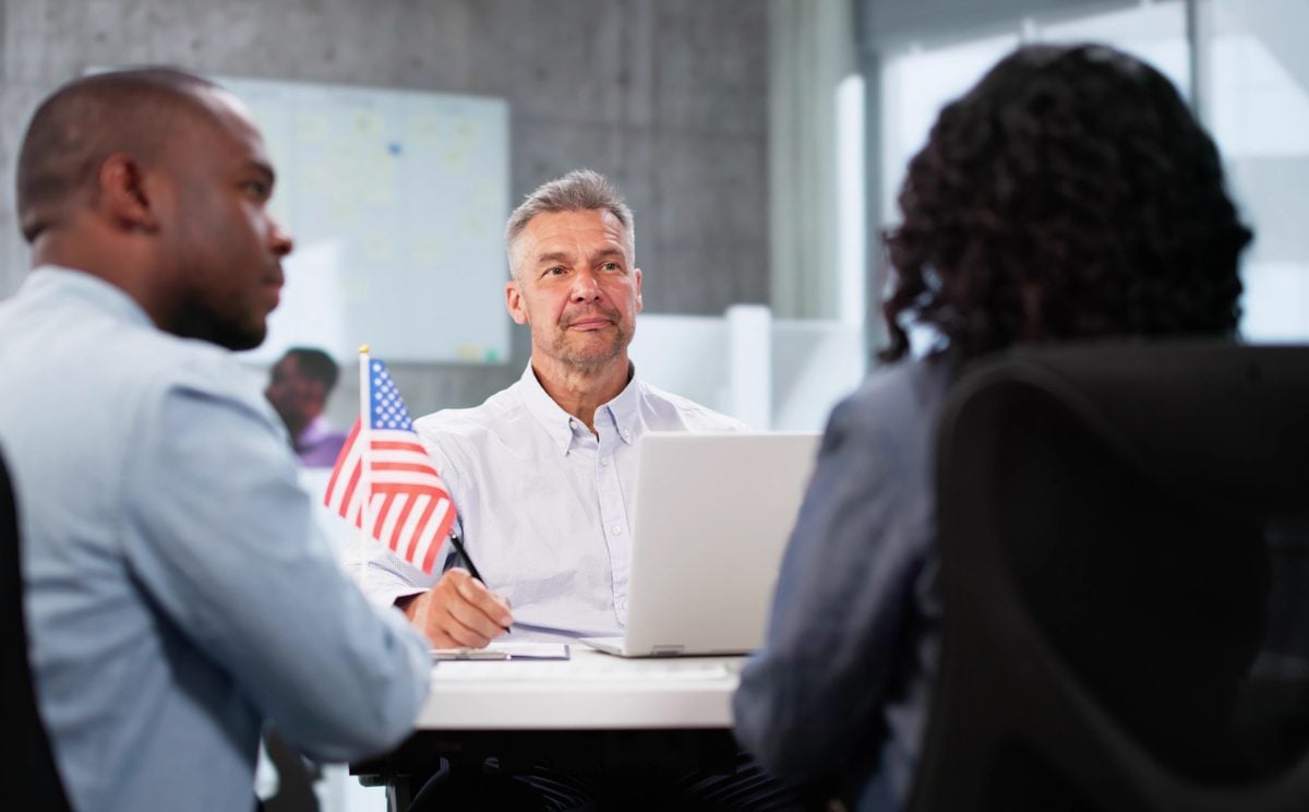 Immigration officer interviewing couple for their Green Card application.