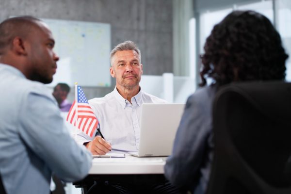 Immigration officer interviewing couple for their Green Card application.