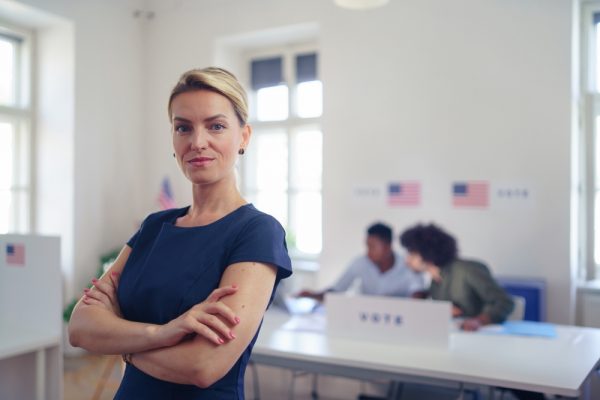 Woman standing in front of the registration table at her polling location.
