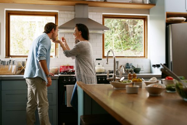 Happy couple cooking together in their kitchen.