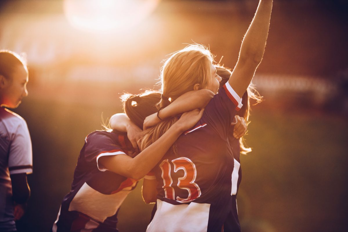 Female soccer players celebrating together.