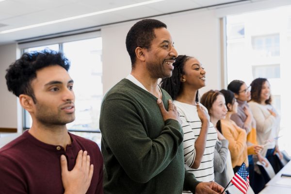 A group of people reciting the Oath of Allegiance at a naturalization ceremony.