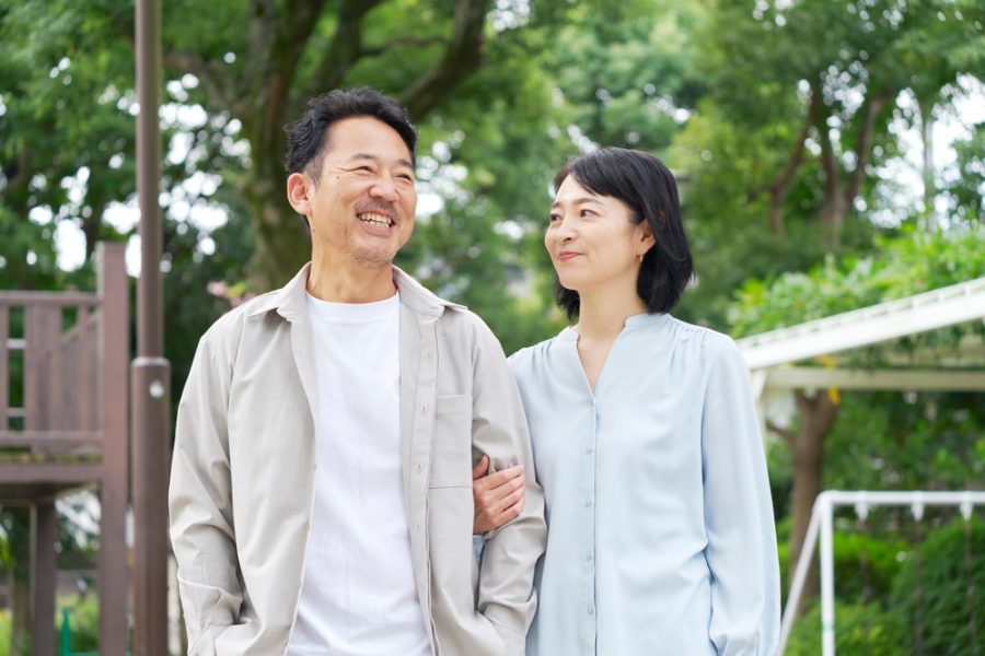 Married couple smiling at each other standing in their backyard
