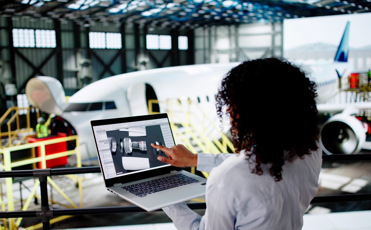 Aerospace engineer reviewing designs on her laptop.