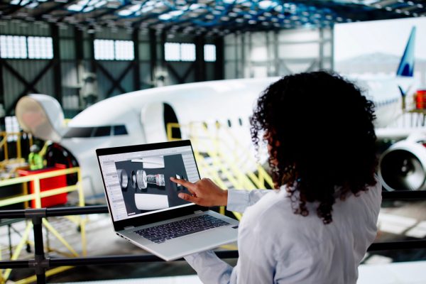Aerospace engineer reviewing designs on her laptop.