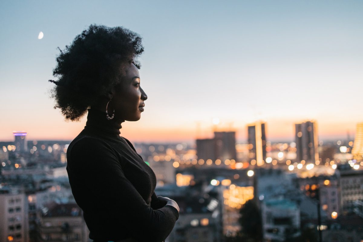 Confident woman overlooking city skyline.