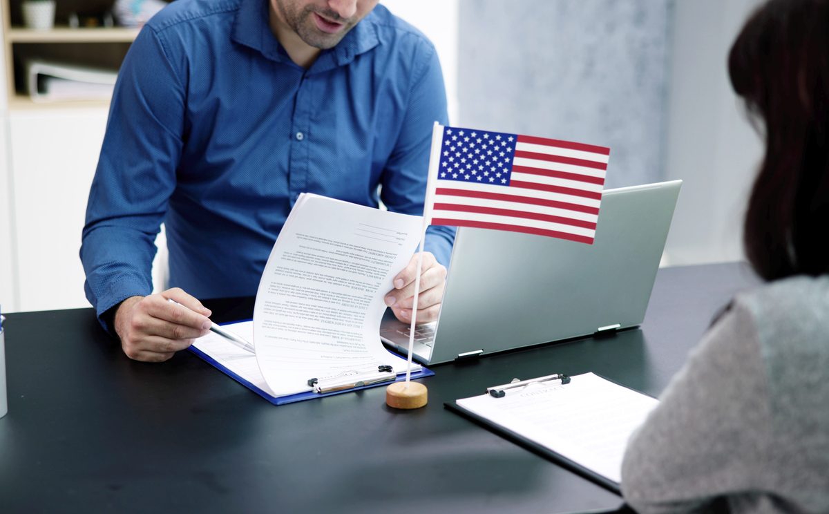 Immigration interview with officer looking over documents.