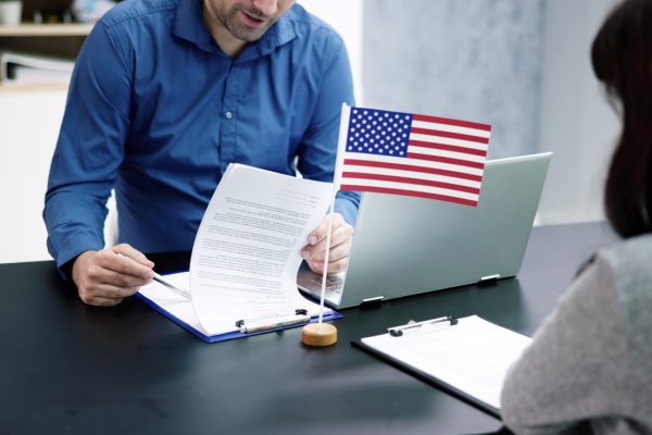 Immigration interview with officer looking over documents.