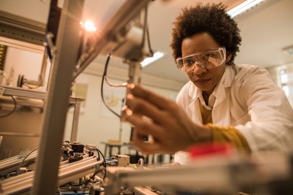 Worker using robotic equipment in a lab.