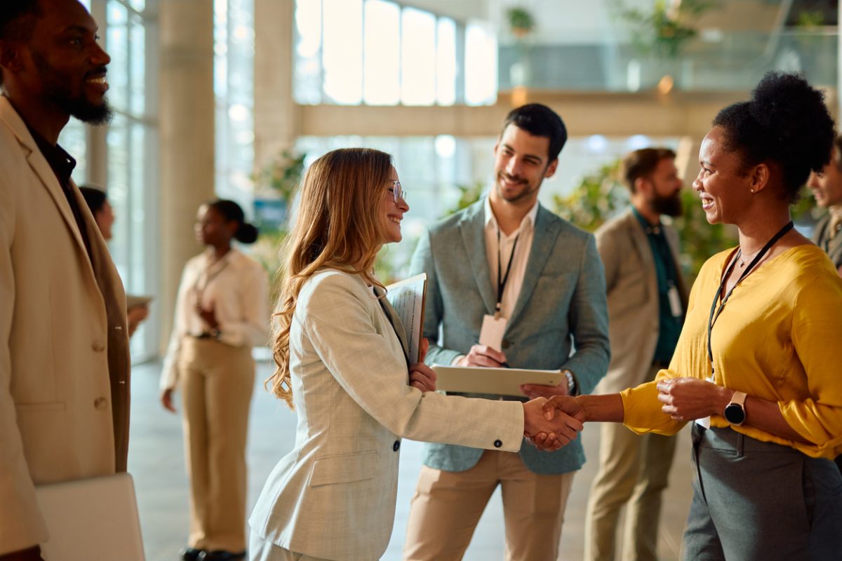 Two businesswomen shaking hands during a conference meeting.