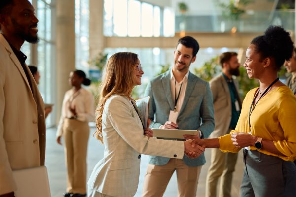Two businesswomen shaking hands during a conference meeting.