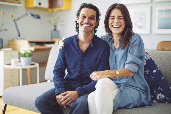 Two siblings sitting together for a family portrait on the couch