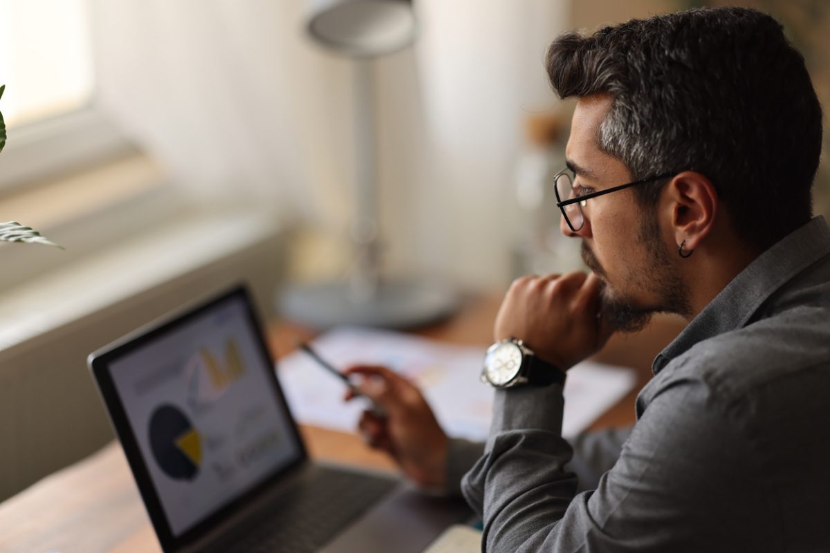 Investor looking at financial data to make a decision on how to invest.
